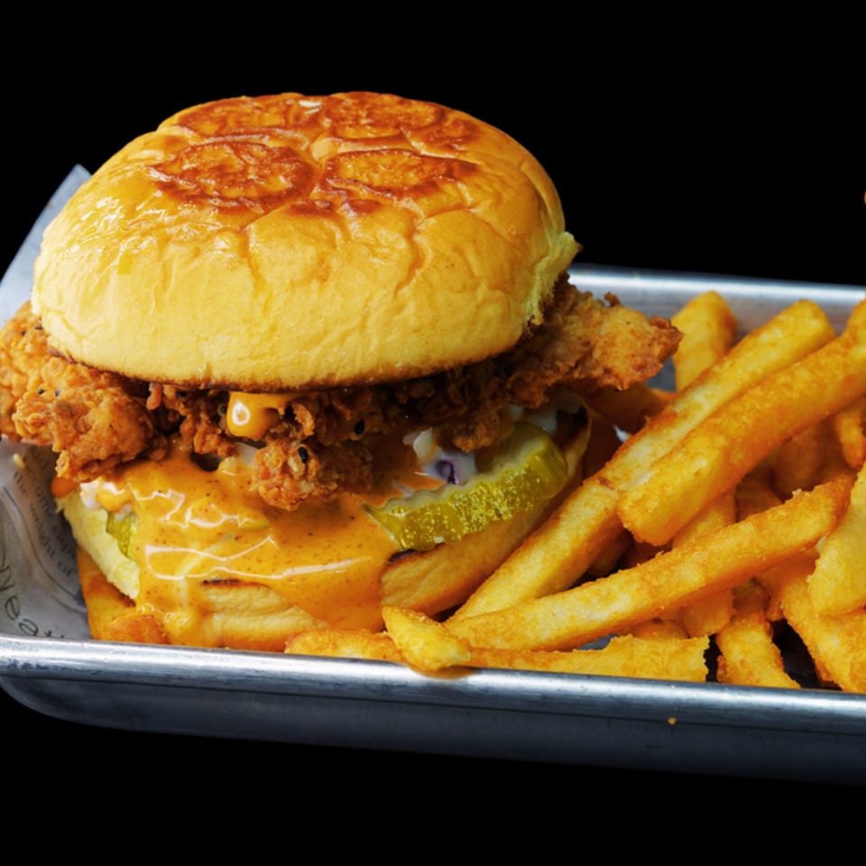 Chick N Burger's fried chicken sandwich with pickles and special sauce, served with fries.